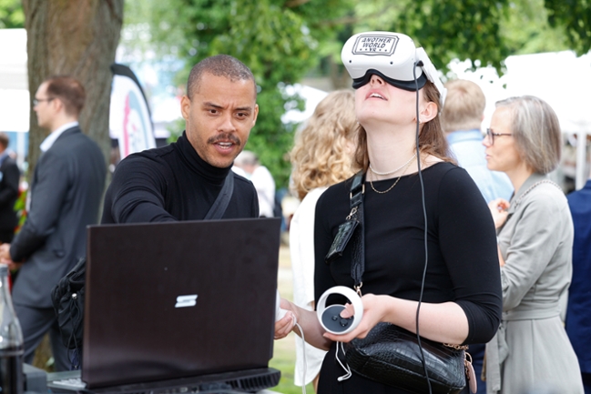 Aussteller und Besucherin mit VR-Brille