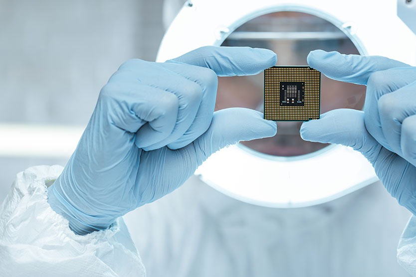 Forscher mit Mikrochip in der Hand, symbolisert das Thema Zukunftsfeld Mikroelektronik